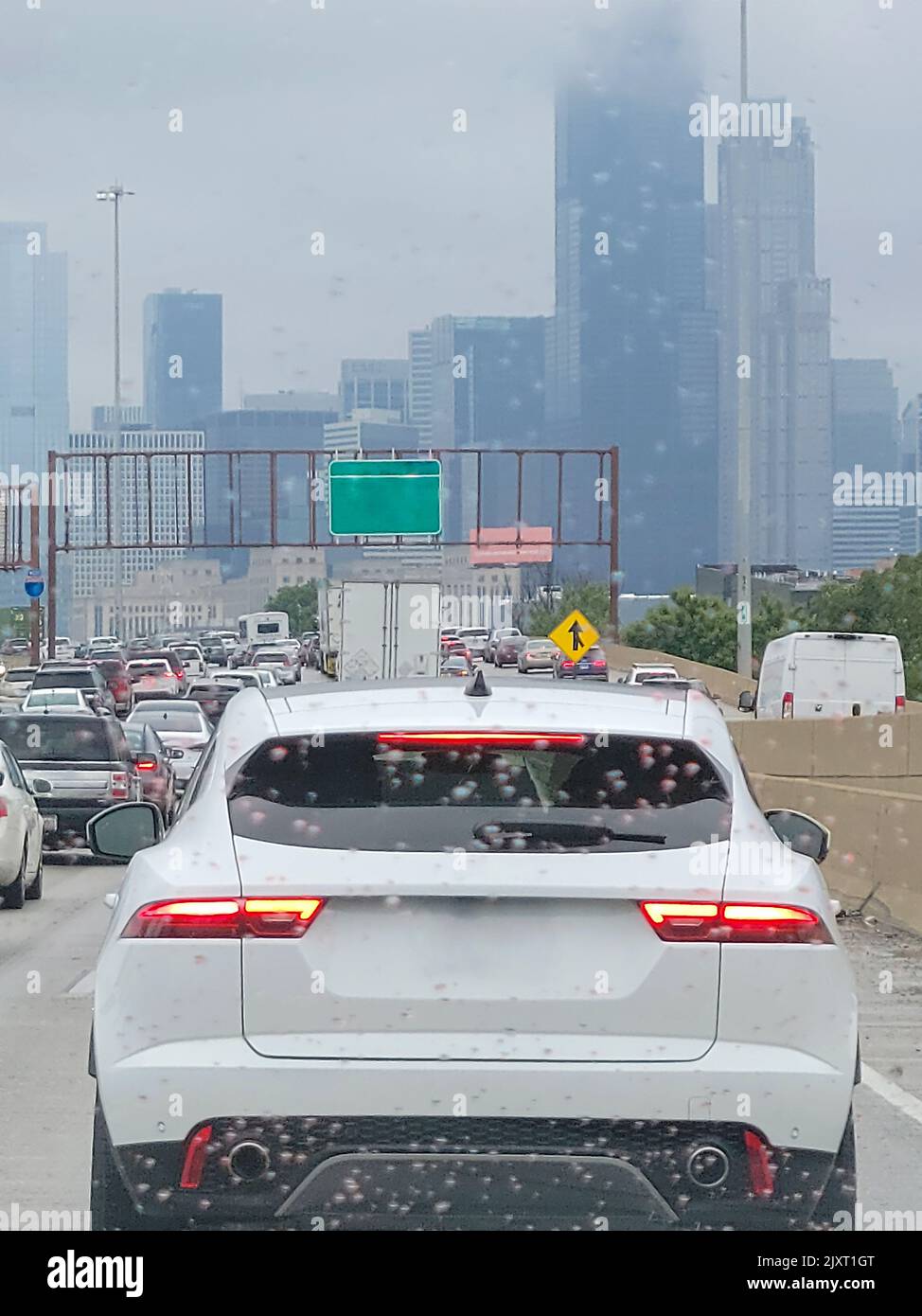 Blick auf den verstopften Stadtverkehr von Chicago durch eine Windschutzscheibe mit Regentropfen Stockfoto