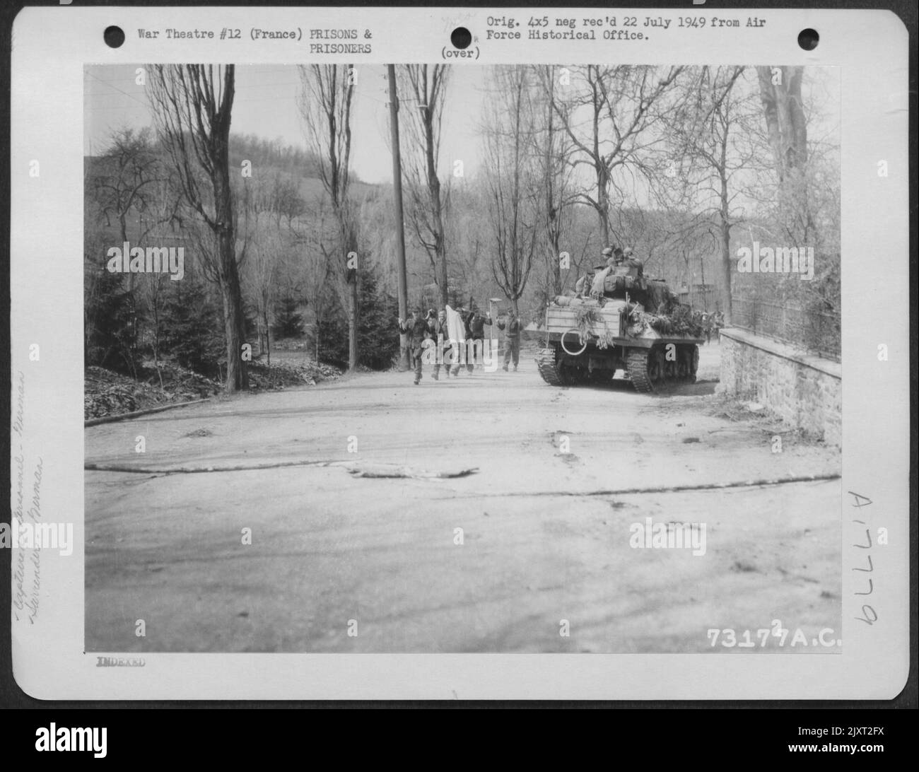 Deutsche Soldaten (mit dem führenden Mann, der eine Flagge des Waffenstillstands trägt) geben sich irgendwo in Frankreich der Besatzung Eines US-Panzers hin. Stockfoto