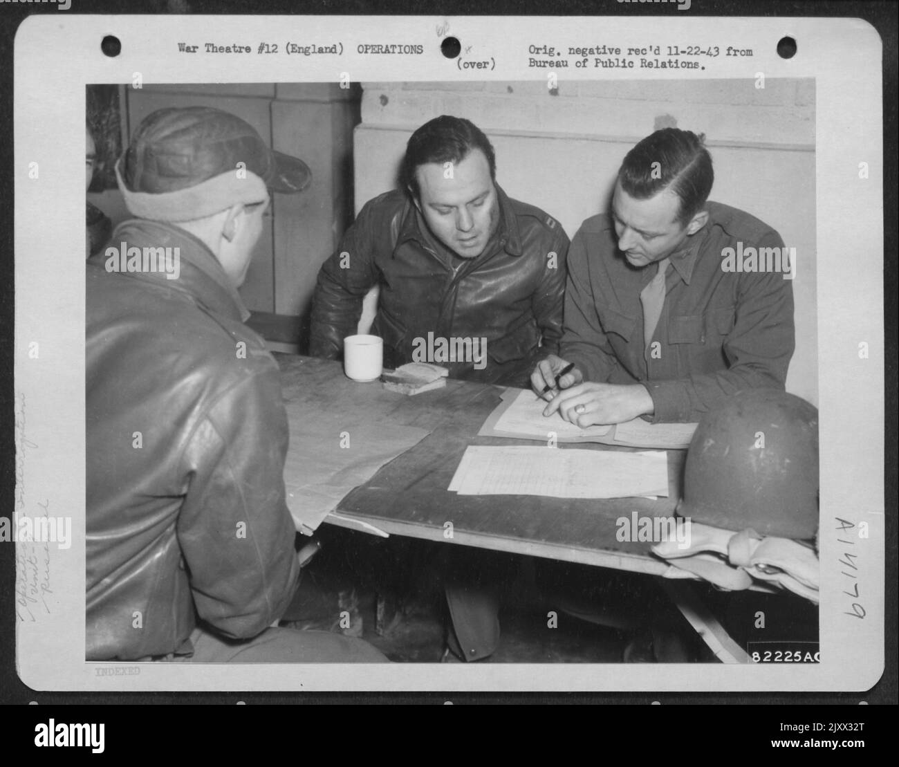 Mitglieder des Bomberkommandos von 8. werden auf einem Luftwaffenstützpunkt irgendwo in England verhört, kurz nachdem sie von Einer Bombenmission über dem feindlichen Territorium zurückgekehrt sind. Von links nach rechts: (Gegenüberliegende Kamera) Capt. J. Lawrence Smith, Caprenteria, Kalifornien, und Capt. Lewis H. We Stockfoto