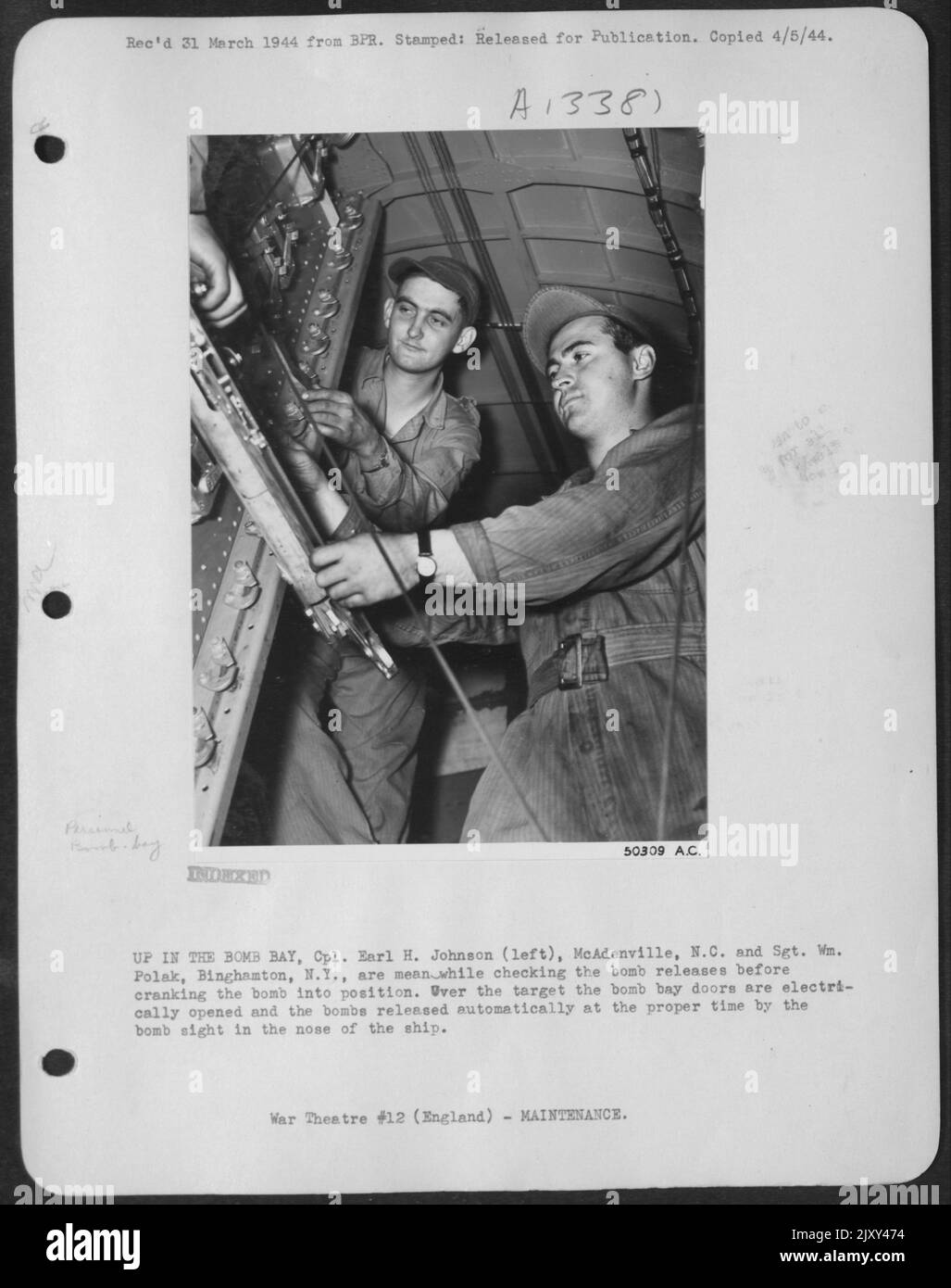 OBEN IN DER BOMBE BAY, CPL. Earl H. Johnson (links), MCADENVILLE, N.C. und Sgt. Wm. Polak, Binghamton, N.Y., überprüft inzwischen die Bombenfreisetzungen, bevor die Bombe in Position gebracht wird. Über dem Ziel die Türen des Bombenregals Stockfoto