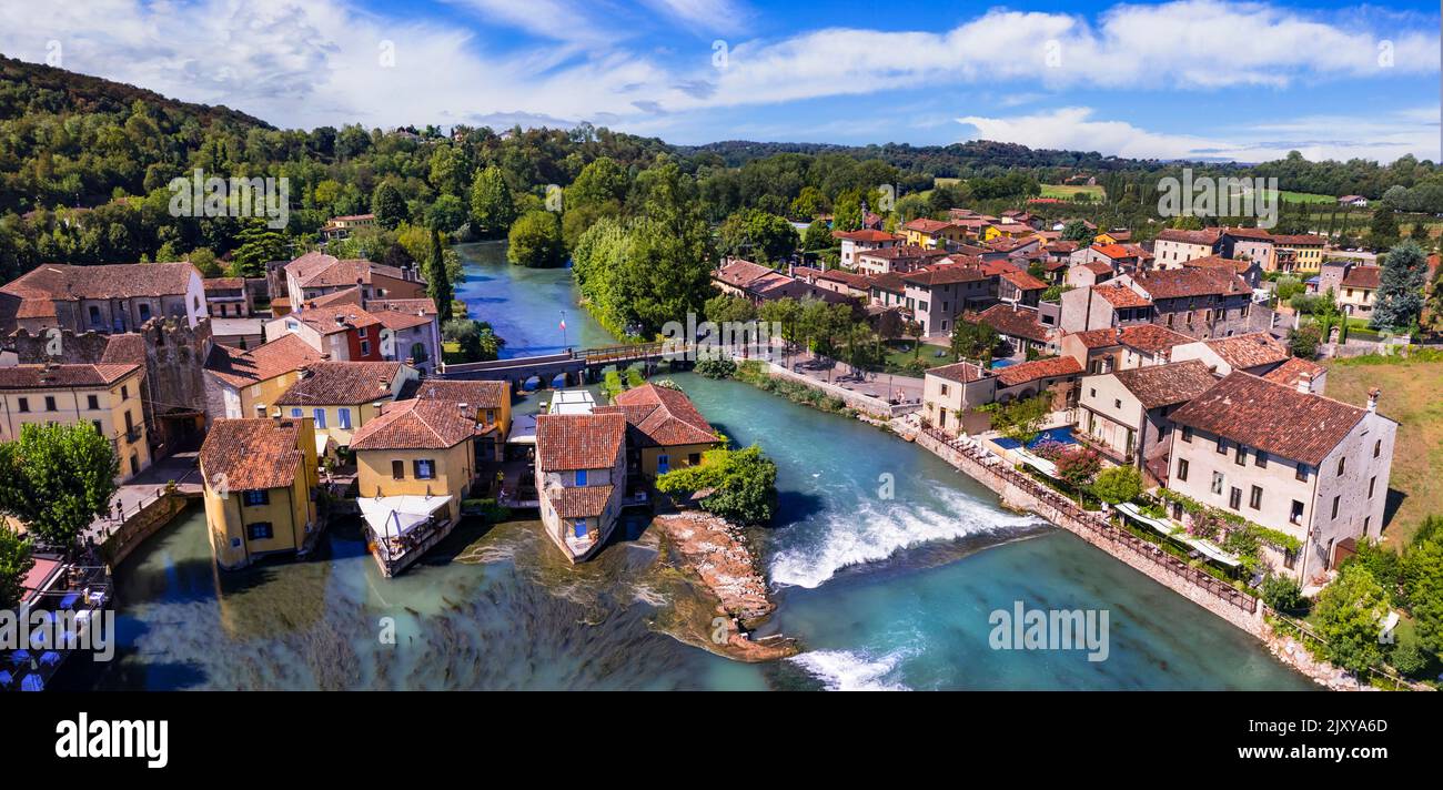 Borghetto sul Mincio Luftbild. Eines der schönsten mittelalterlichen Dörfer Italiens. Bunte Häuser in der Mitte des Flusses und Wasserfälle. Ve Stockfoto