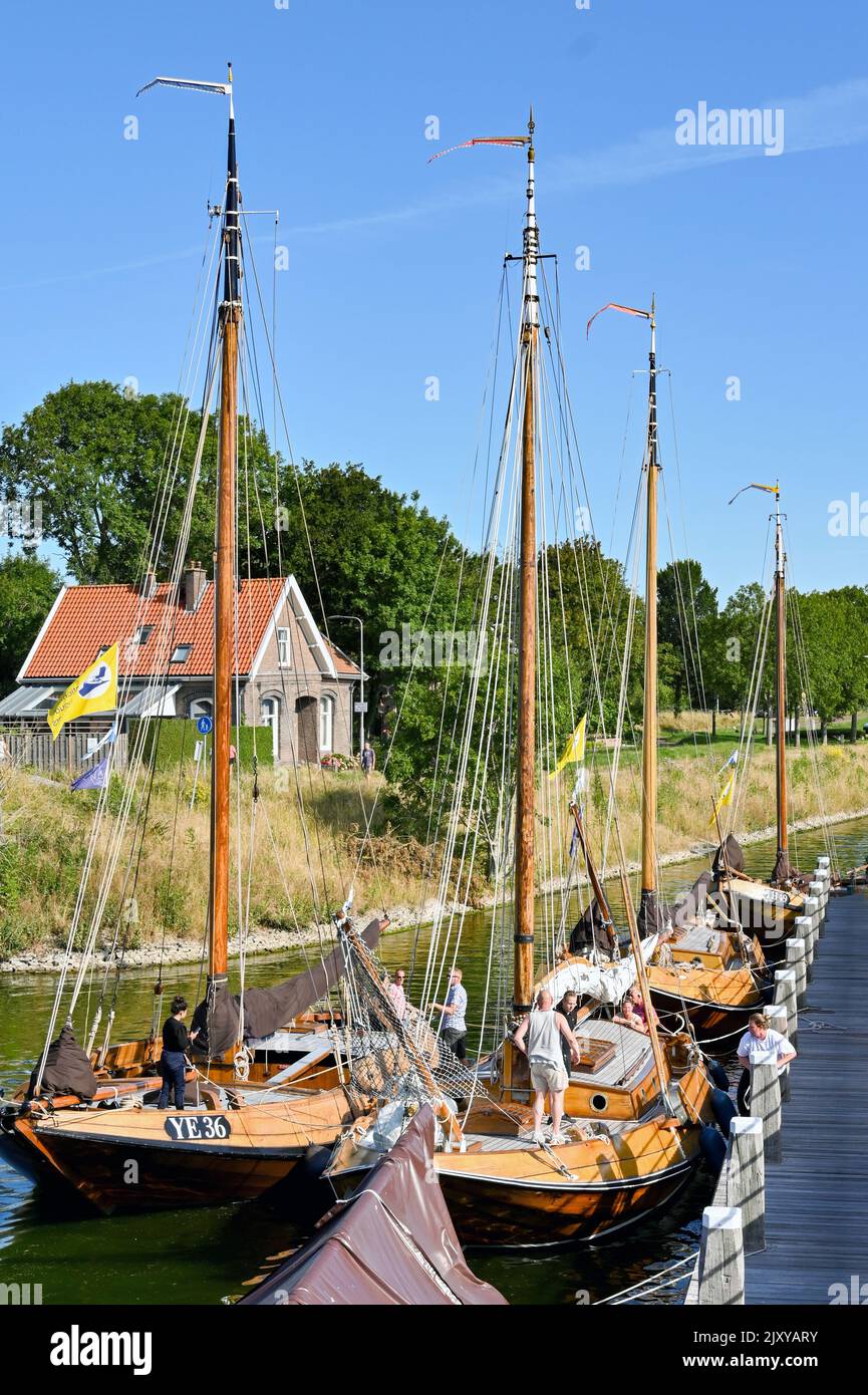 Veere, Niederlande - August 2022: Menschen auf traditionellen hölzernen Segelbooten, die in der Nähe der Stadt festgemacht sind Stockfoto