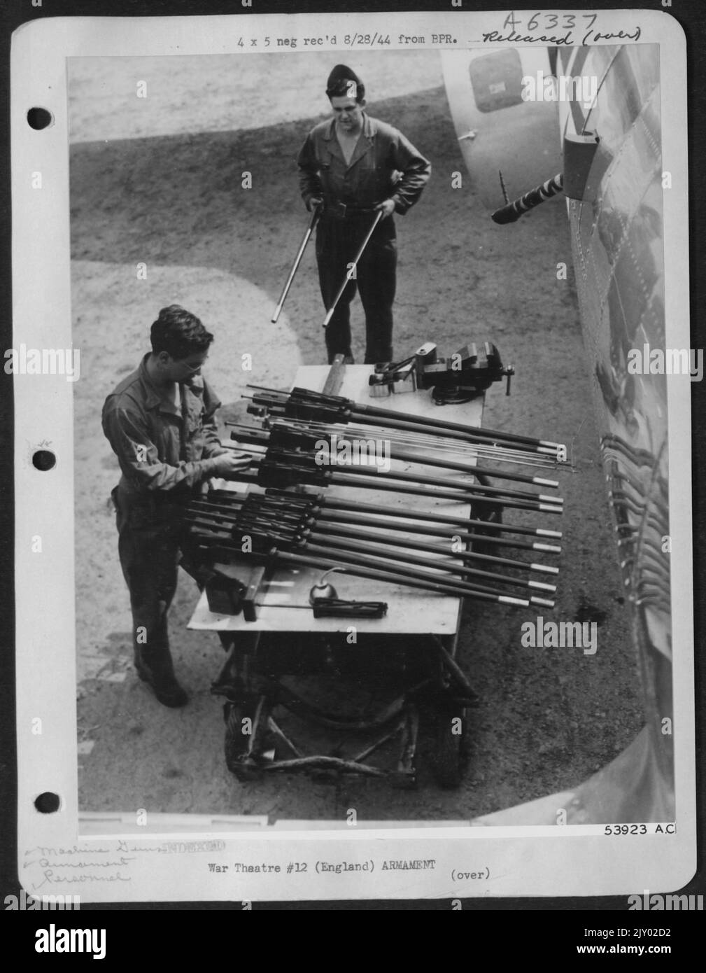 REINIGUNG DER PISTOLE-M/SGT. George F. Frederick, Ridgeway, Penna., justiert die Schraube an den tödlichen Maschinengewehren des ofrt im Kaliber .50, um die Reinigung vorzubereiten. M/Sgt. Manuel G. Fernandez, Donora, Penna., im Hintergrund, bringt einige mehr von der ofrt Stockfoto