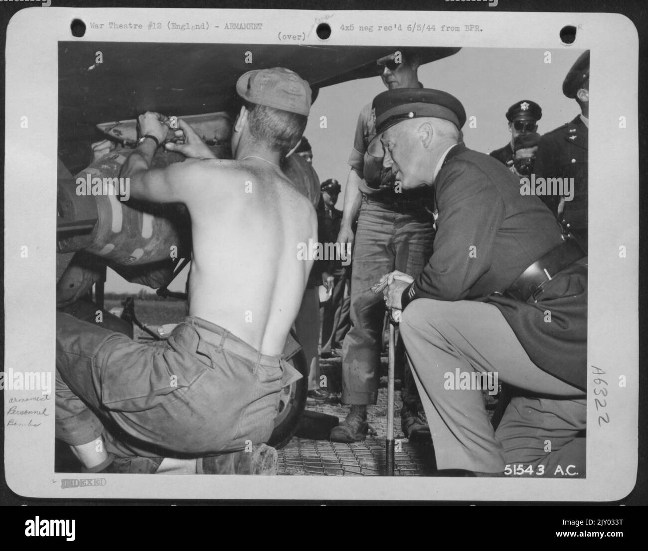 Eine NEUNTE LUFTWAFFENJÄGERSTATION, England:--- LT. General George „Blood and Guts“ Patton, der eine 9. AF Mustang Fighter-Bomber-Basis besucht, ist an der Panzerung dieser schnell harten P-51s interessiert. General Patton wird von Sgt gezeigt. Leroy Stokes Stockfoto