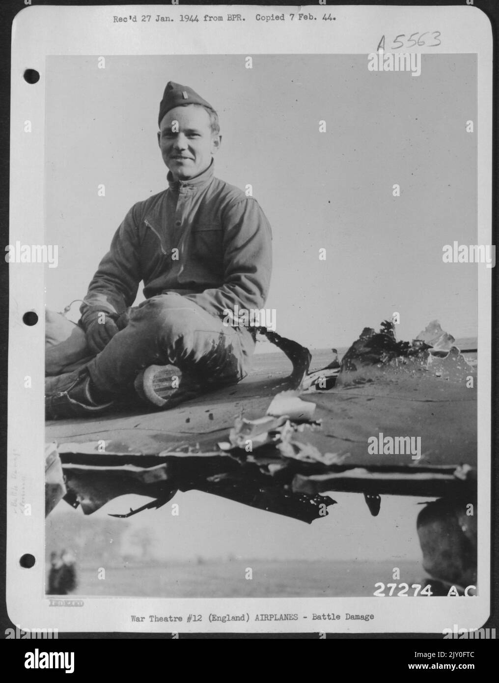 EINE ACHTE AAF BOMBER-KOMMANDOSTATION, ENGLAND. 2. LT. Owen D. (Cowboy) Roane, Pilot der Boeing B-17 der Acht-Luftstreitkräfte, die Fluglotse „Torchy III“, sitzt neben dem 20-mm-Kanonenmuschelloch, das von Nazi-Kämpfern in den Flügel seines großen Bombers gestrahlt wurde Stockfoto
