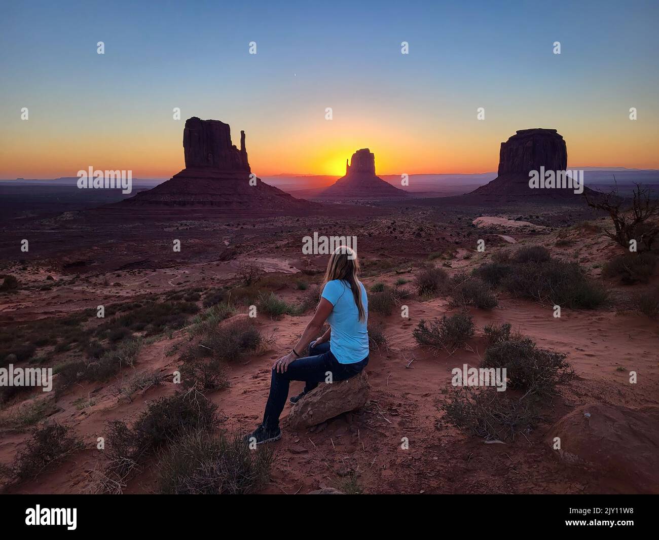 Frau, die die wunderschöne Landschaft bei Sonnenaufgang im Monument Valley, Utah, beobachtet Stockfoto