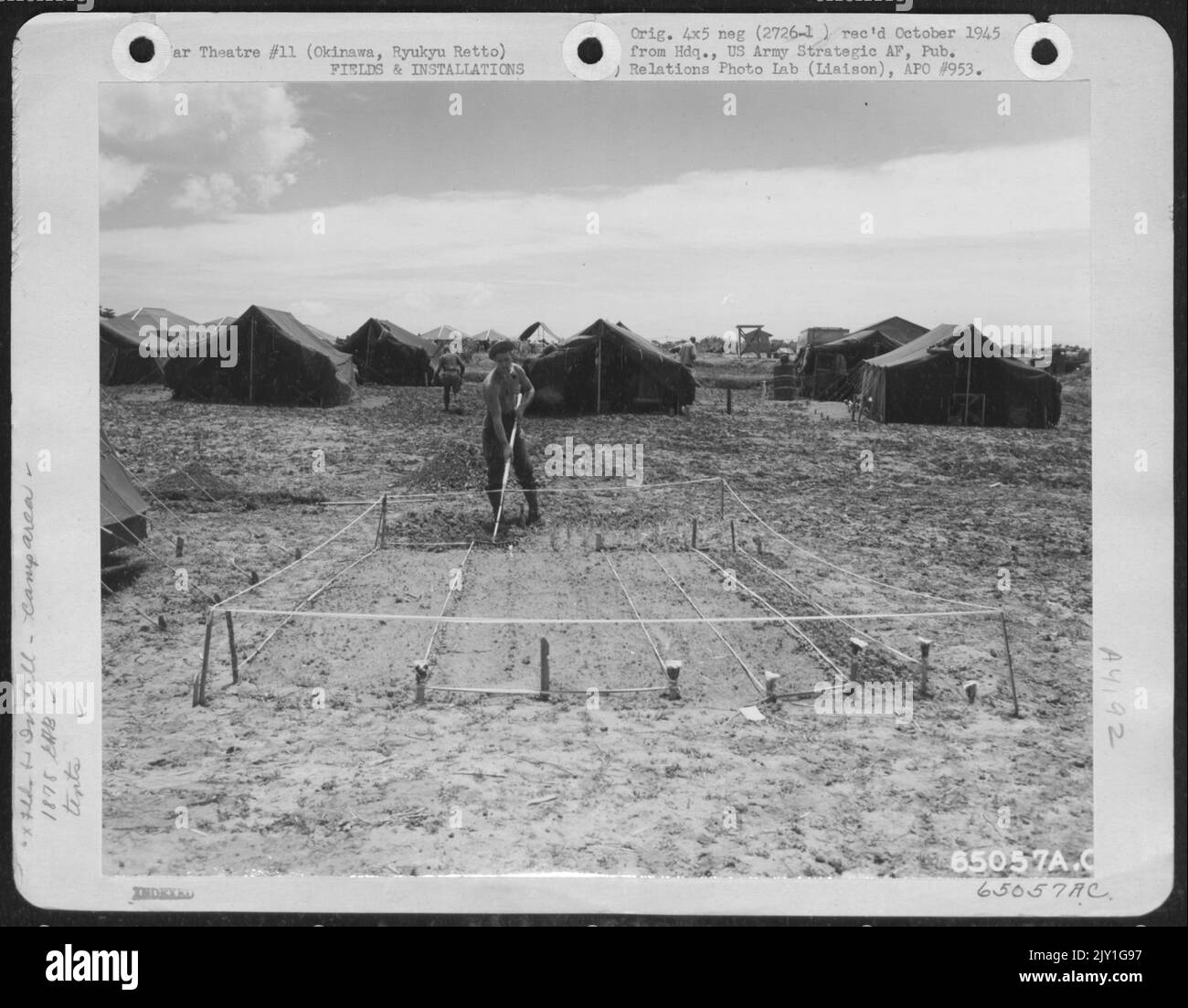 Ein 'Gi' bereitet Ein kleines Gartengrundstück in der Nähe seines Zeltes im Lagerbereich des Flugbataillons der Ingenieure von 1878Th auf Okinawa, Ryukyu Retto, vor. Mai 1945. Stockfoto