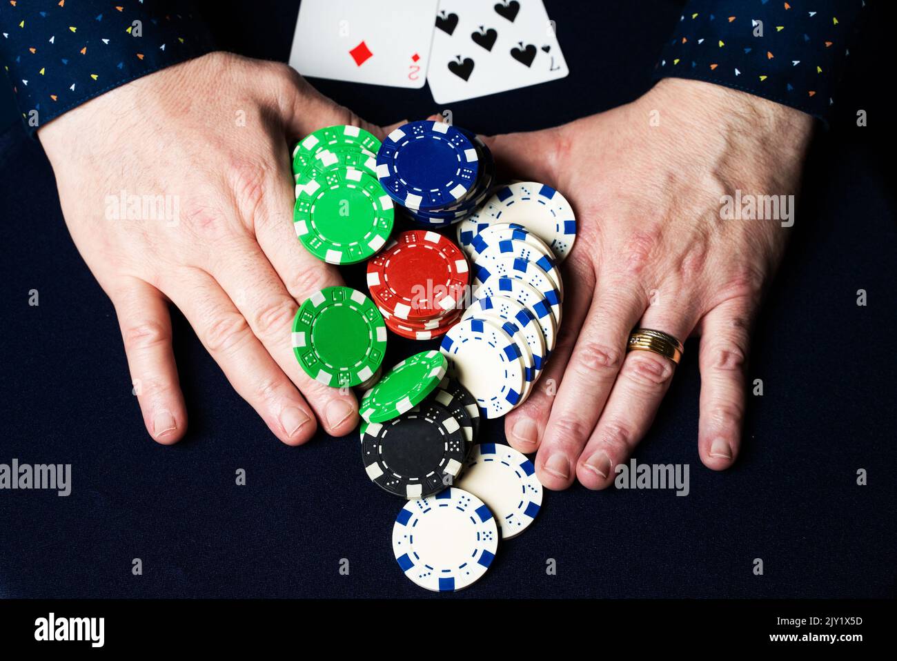 Mann setzt alle seine Chips in Texas Hold' EM und hält gleichzeitig die schlechteste Hand. Er blufft Stockfoto