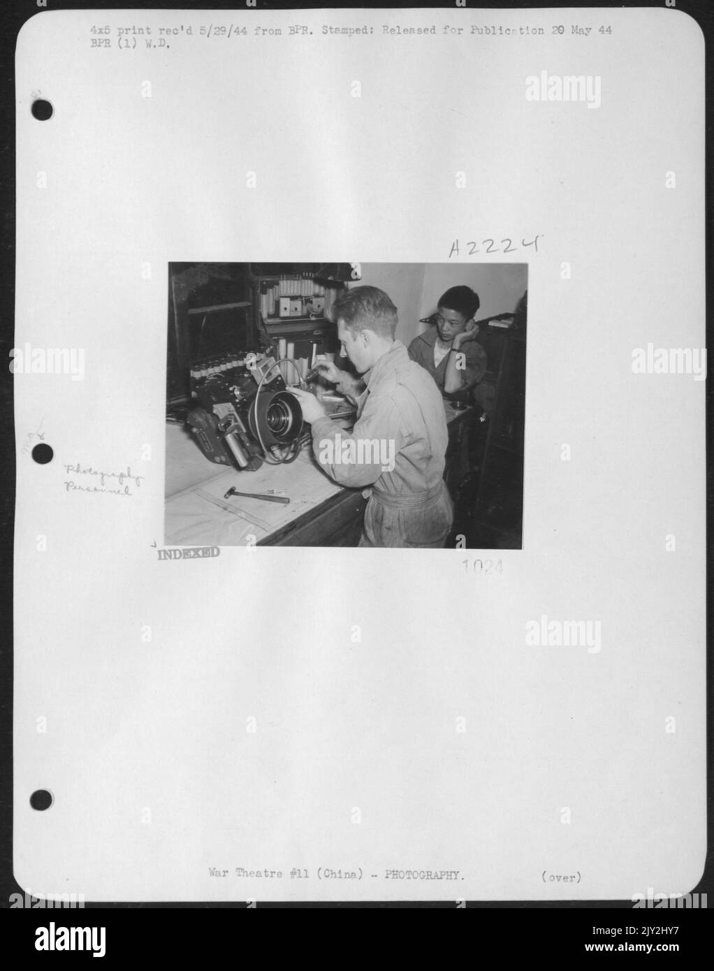 M/Sgt. Charles H. Stoopes, 207 Shore Road, Somers Point, N.J. Eine Kamera reparieren, eine der Aufgaben, die er im Fotolabor der Liberatoren Chinas macht. Sammy Sanling, Ein Chinesischer Verwungener, Der Von Den Lab Boys Adoptiert Wurde, Beobachtet Ihn Bei Der Arbeit. 308Th Bomb Group. Stockfoto M/Sgt. Charles H. Stoopes, 207 Shore Road, Somers Point, N.J. Eine Kamera reparieren, eine der Aufgaben, die er im Fotolabor der Liberatoren Chinas macht. Sammy Sanling, Ein Chinesischer Verwungener, Der Von Den Lab Boys Adoptiert Wurde, Beobachtet Ihn Bei Der Arbeit. 308Th Bomb Group. Stockfoto