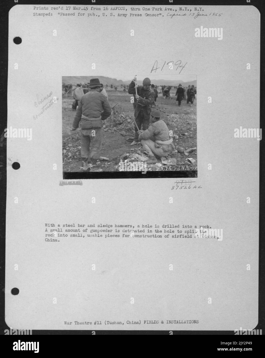 Mit Einer Stahlstange und einem Sled Hammers wird Ein Loch in Einen Felsen gebohrt. Eine kleine Menge Gunpowder wird im Loch gezündet, um den Felsen in kleine, nutzbare Stücke für den Bau des Flugfeldes in Tushan, China, zu Spalten. Stockfoto