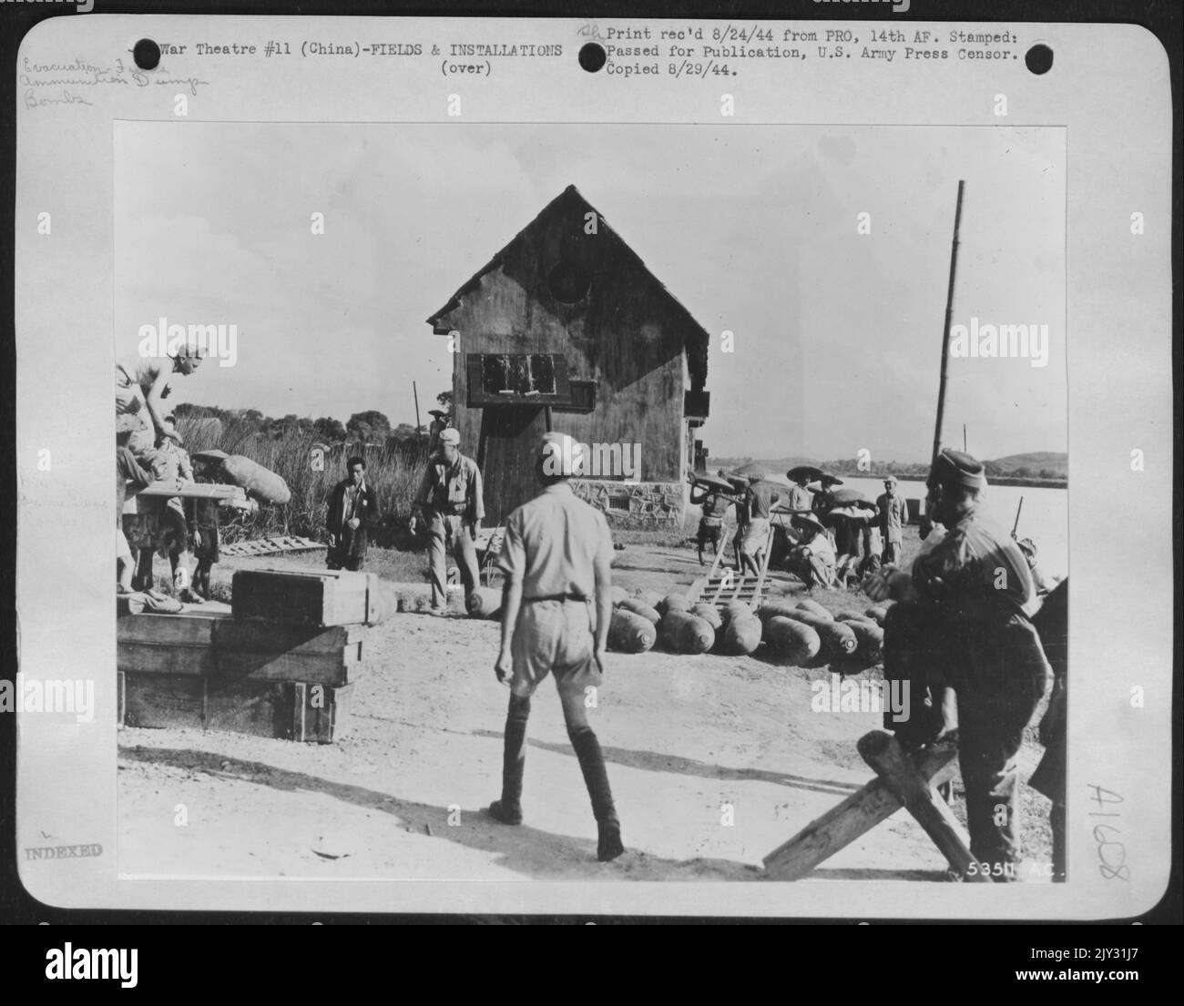 Soldaten der Luftwaffe 14. in China entfernen mithilfe von Coolies Bomben aus der Munitionsdeponie, um das Flugfeld Hengyang aufzugeben. Stockfoto