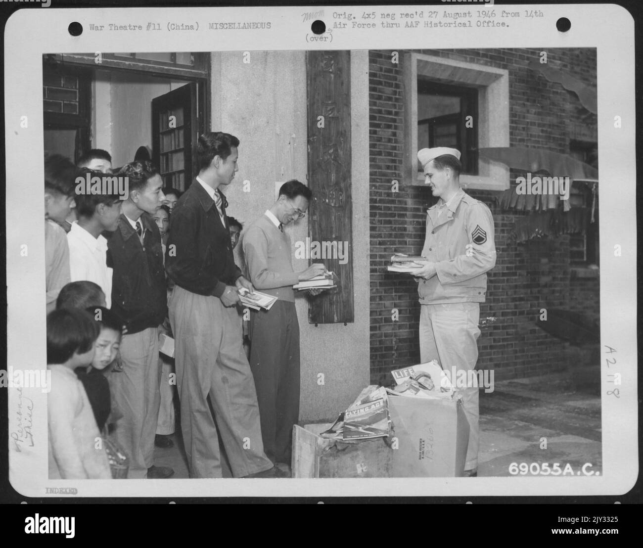 S/Sgt. John Reilly von der Luftwaffe 14. stellt den chinesischen Studenten in Chungking, China, englische Bücher und Zeitschriften vor. 9. Oktober 1945. Stockfoto