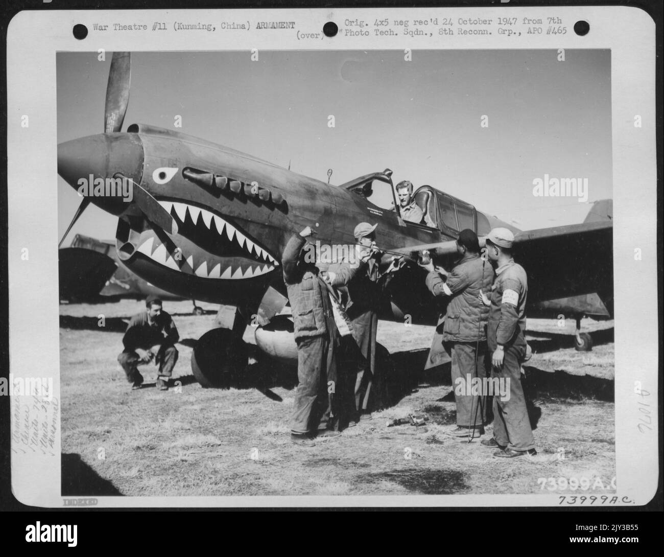 Chinesische Soldaten und Waffler der 74. Jagdgeschwader, 23. Fighter Group, Check the Guns on A Curtiss P-40 at Kunming, China, 1. Februar 1943. Die Waffler sind: T/Sgt. Hugh L. Jenkins von Colorado S/Sgt. Harry L. Gray von Cisco, Texas S/Sgt. HY D. S Stockfoto
