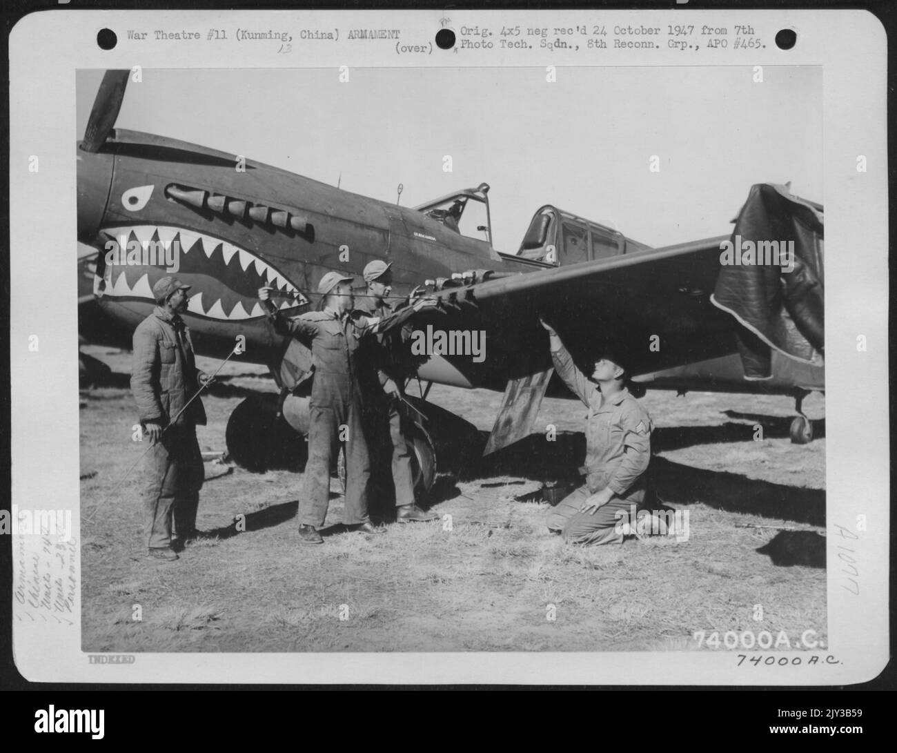 Zwei chinesische Soldaten helfen den Panzern S/Sgt. Harry L. Gray von Cisco, Texas S/Sgt. Donald W. Dell, Los Angeles, Kalifornien, von der 74. Fighter Squadron, 23. Fighter Group, Check the Guns on A Curtiss P-40 at Kunming, China. 1. Februar 1943. Stockfoto