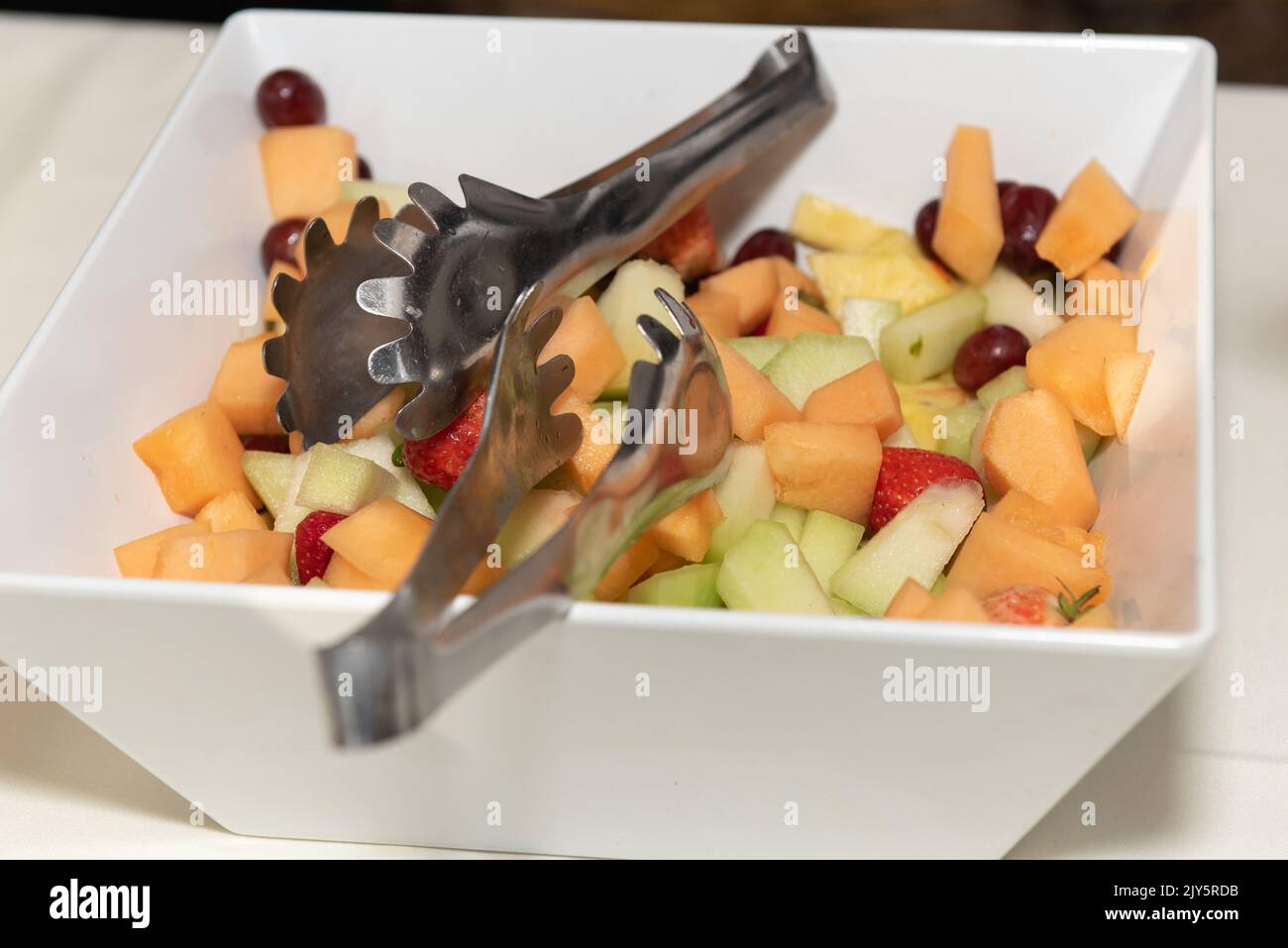 Freshy Chopped Produce macht einen erfrischenden Obstsalat für die Gäste, um sich selbst zu essen zu servieren. Stockfoto