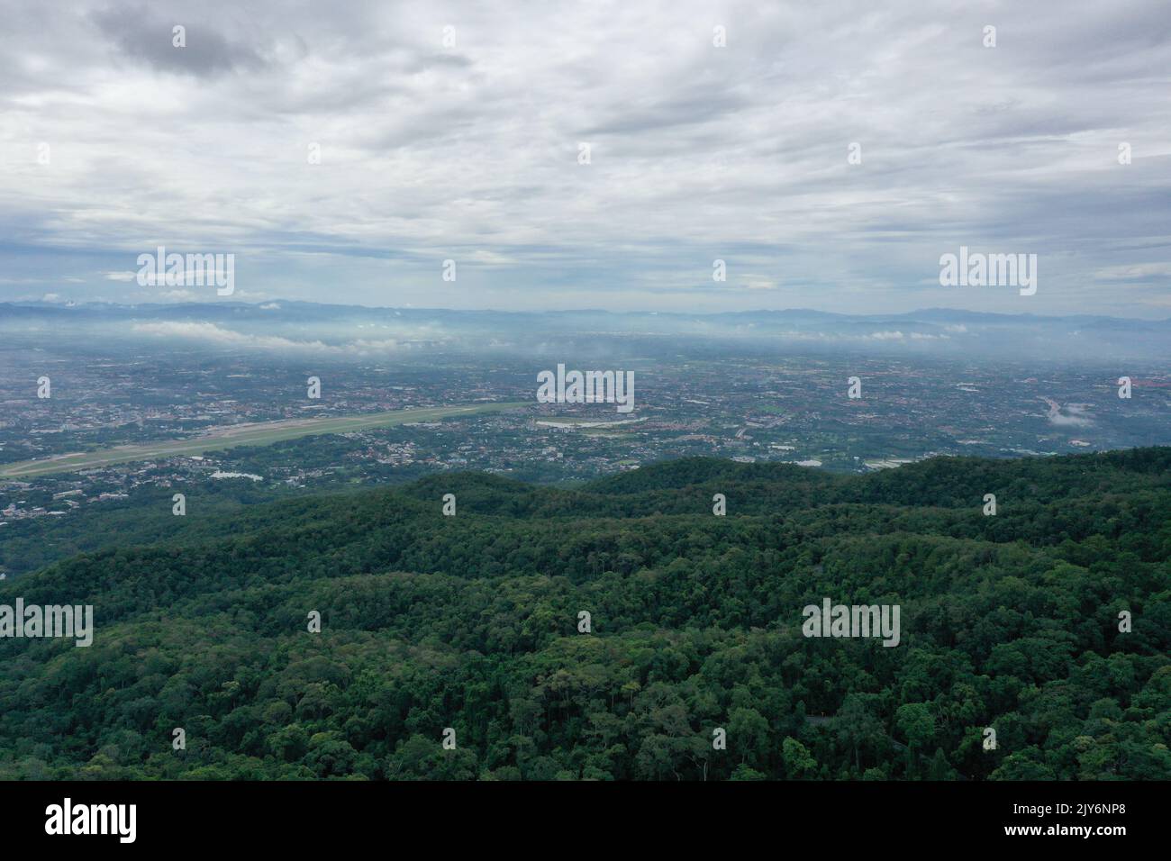Blick von oben auf den Berg in Chiang Mai City, Thailand. Weiße Wolken und Staub sind über dem Berg, während Städte weit entfernt zu sehen sind. Stockfoto