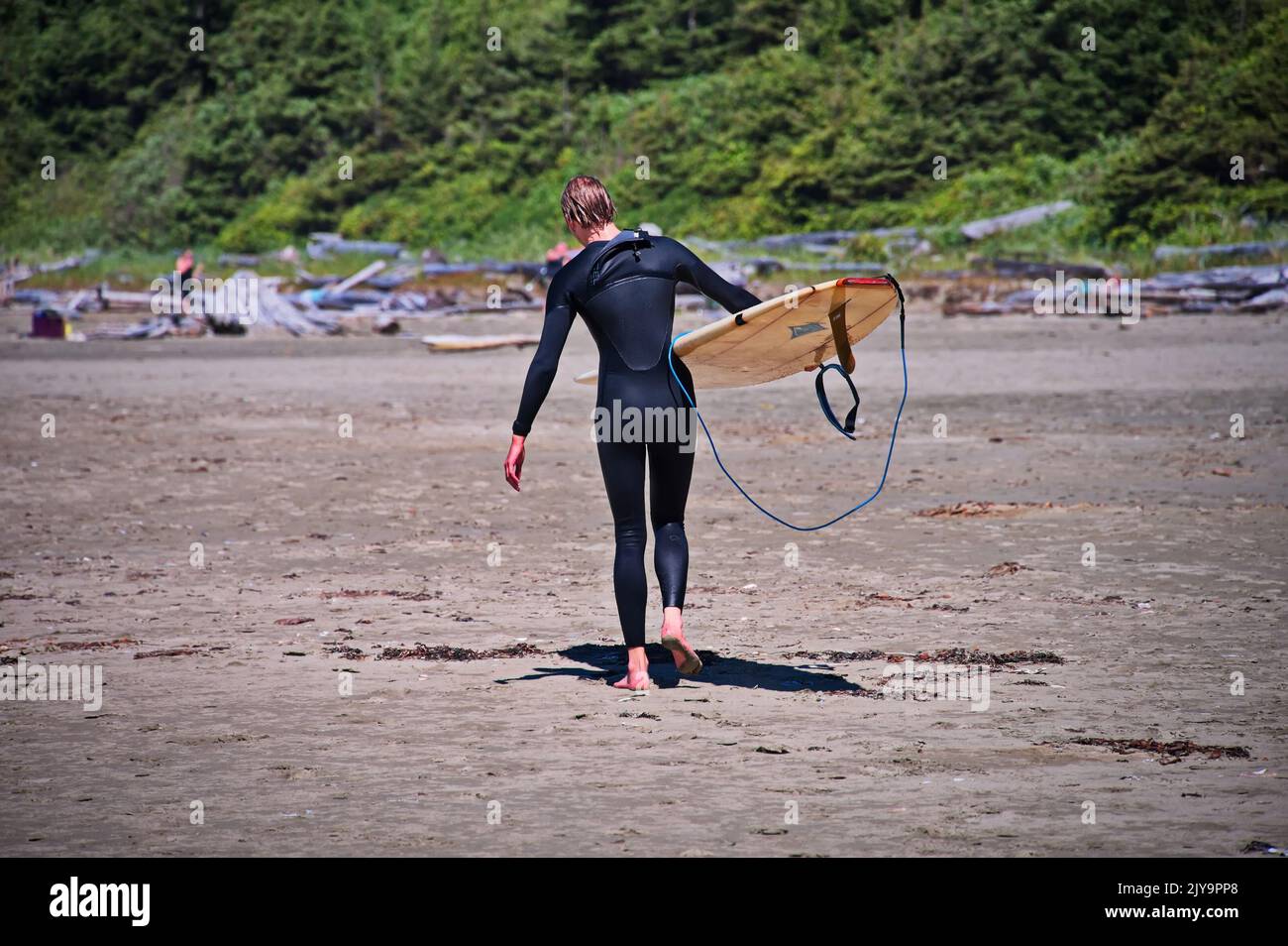 Surfer beim Strandspaziergängen in Tofino, Kanada mit dem Board Stockfoto