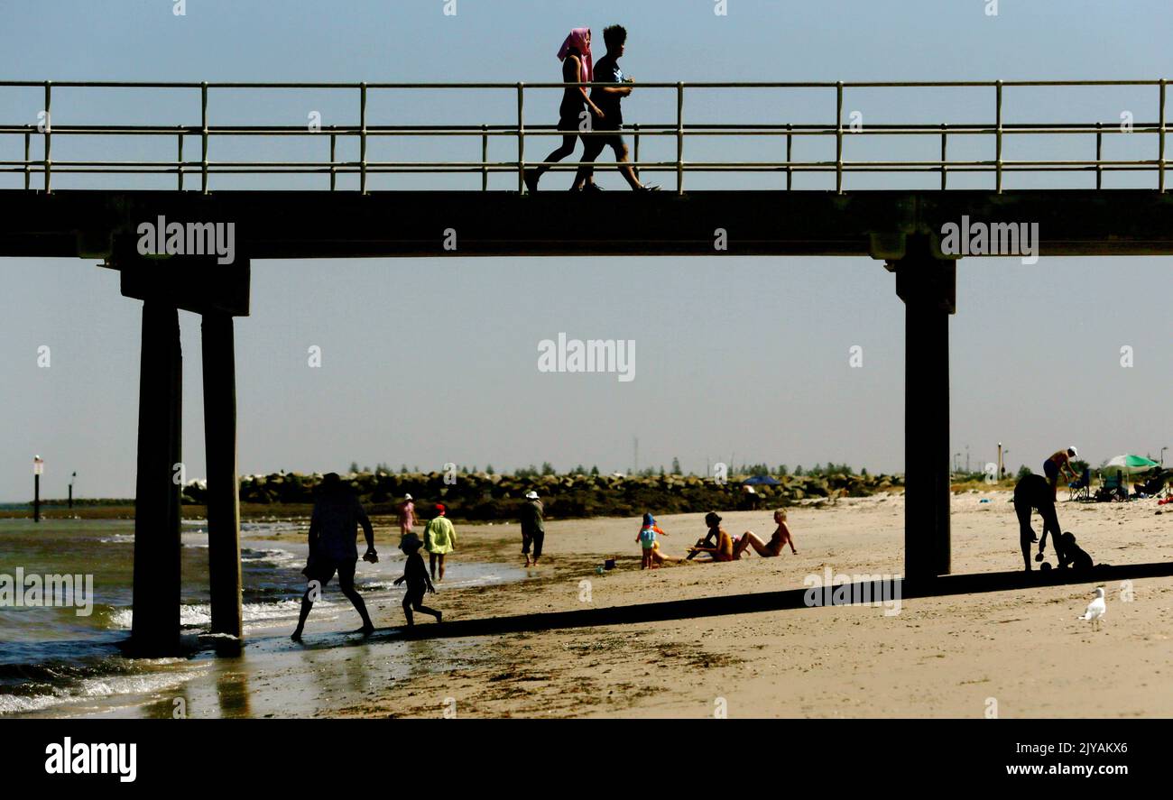 Strandgänger werden am Glenelg Beach in Adelaide, Donnerstag, 30. Januar 2020, gesehen. Die südaustralischen Behörden stellen sich auf einen Tag mit hoher Brandgefahr durch steigende Temperaturen und Wind ein. (AAP Image/Kelly Barnes) KEINE ARCHIVIERUNG ** NUR FÜR REDAKTIONELLE ZWECKE ** Stockfoto