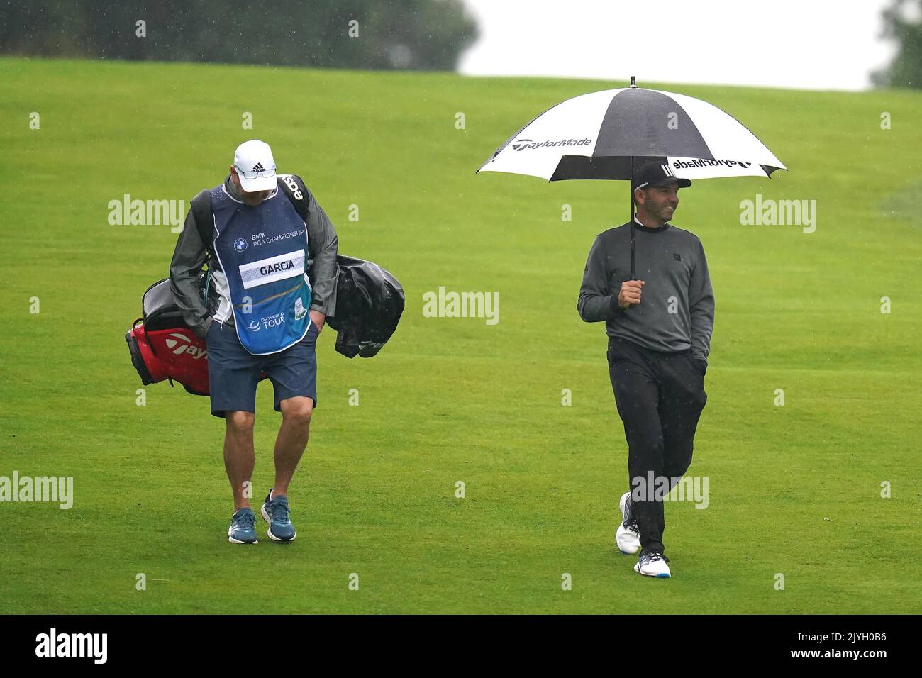 Der Spanier Sergio Garcia (rechts) mit seinem Caddy Glen Murray auf dem Fairway 5., als es am ersten Tag der BMW PGA Championship im Wentworth Golf Club, Virginia Water, regnet. Bilddatum: Donnerstag, 8. September 2022. Stockfoto