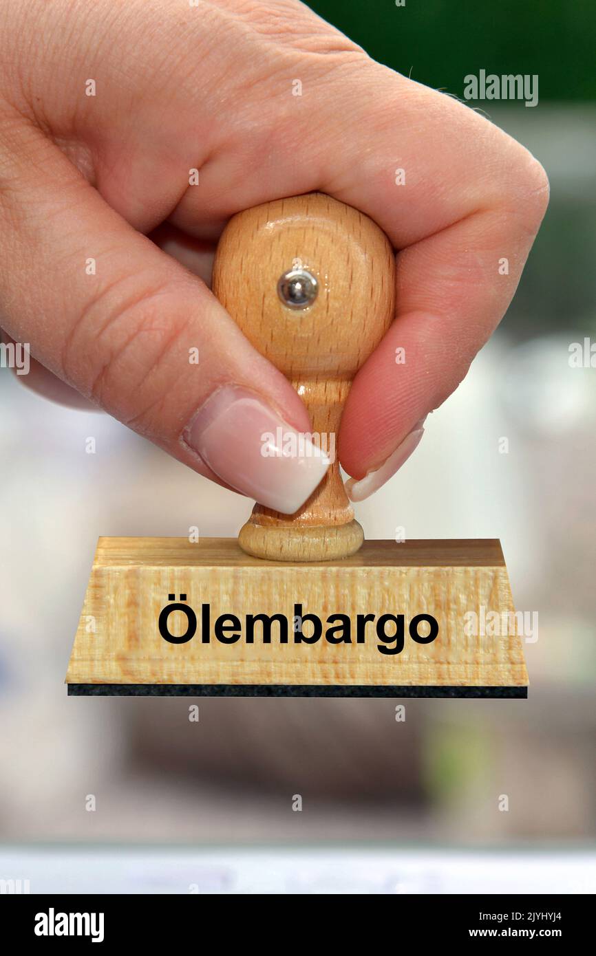 Frauenhand mit Stempelbeschriftung Oelembargo, Gasembargo, Deutschland Stockfoto