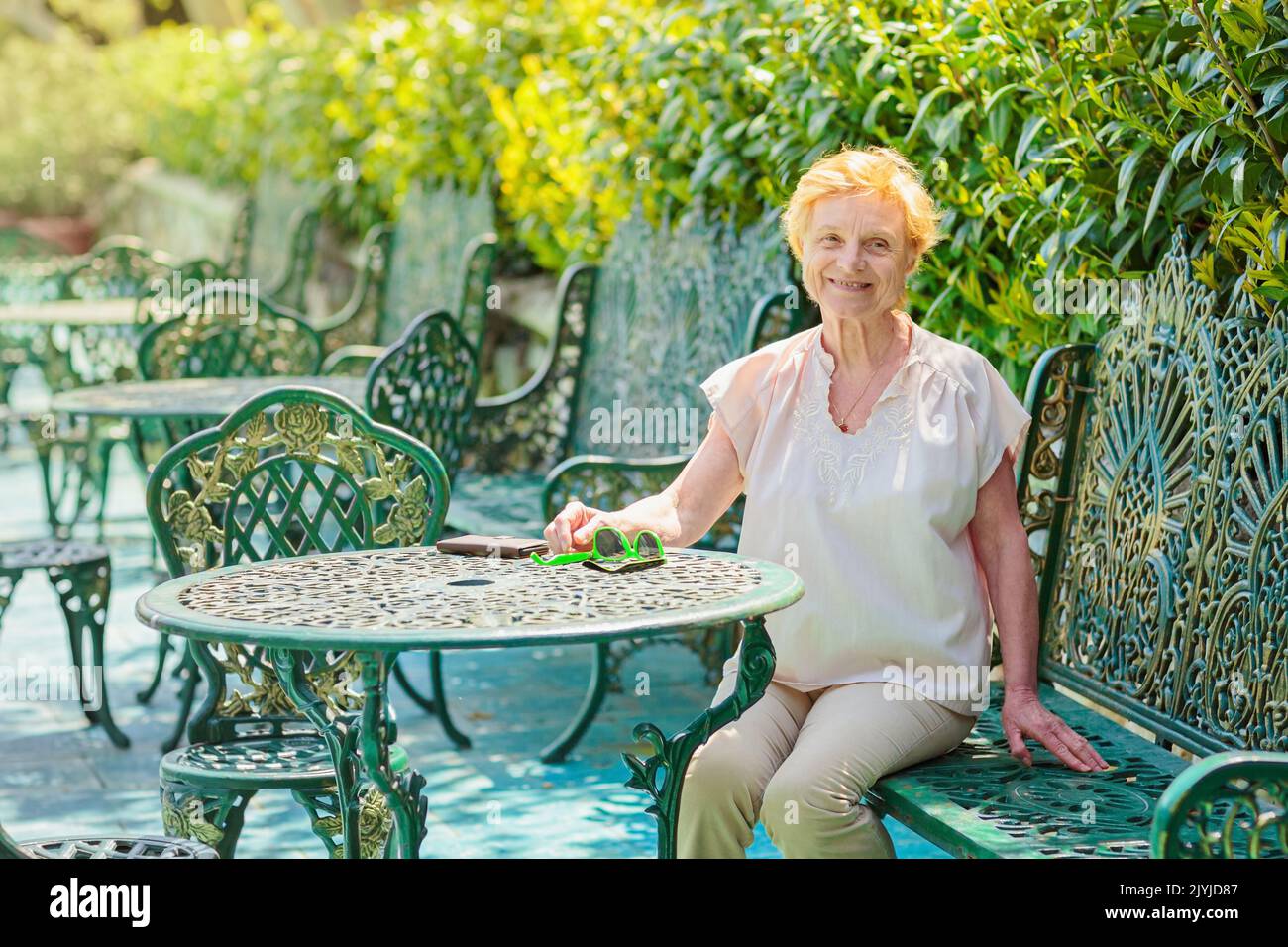 Reife attraktive Frau Reisende allein auf der Terrasse des Cafés sitzen Stockfoto