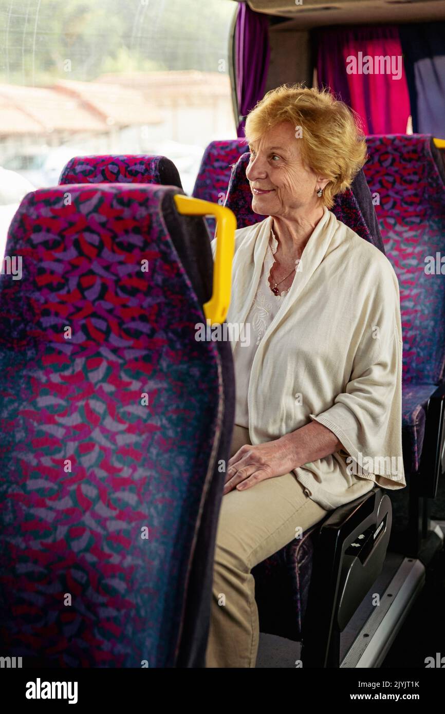 Ältere Frau, die im Reisebus sitzt und auf einen Ausflug wartet Stockfoto