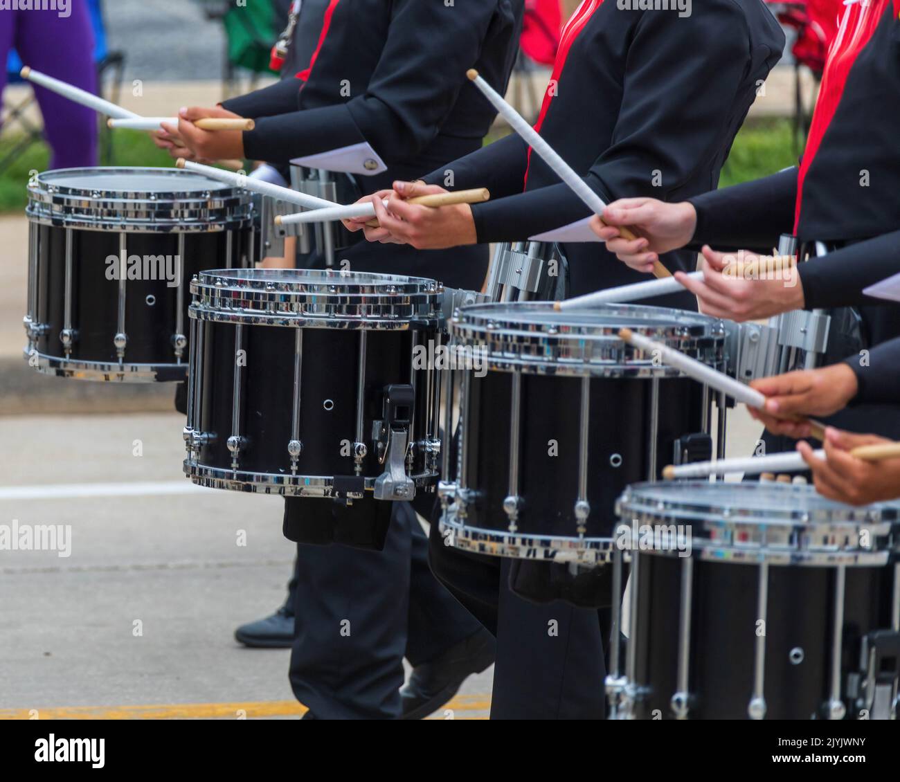 Bass-Teil einer marschierenden Band-Drum-Line, die sich für eine Parade aufwärmt Stockfoto