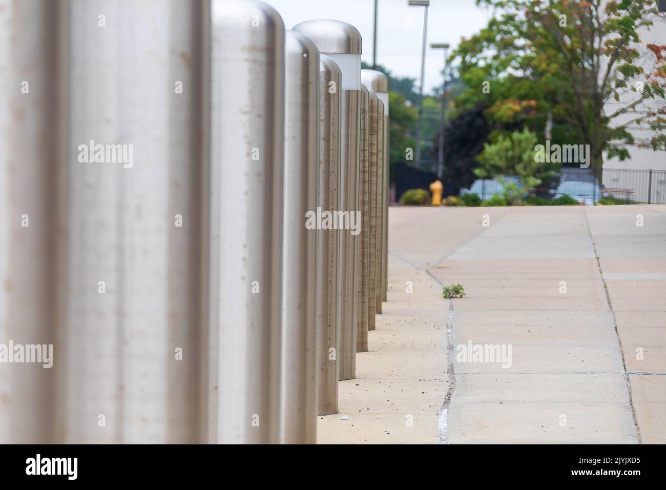 Reihe von Verkehrsbarrieren, die einen Bürgersteig und ein Gebäude schützen Stockfoto