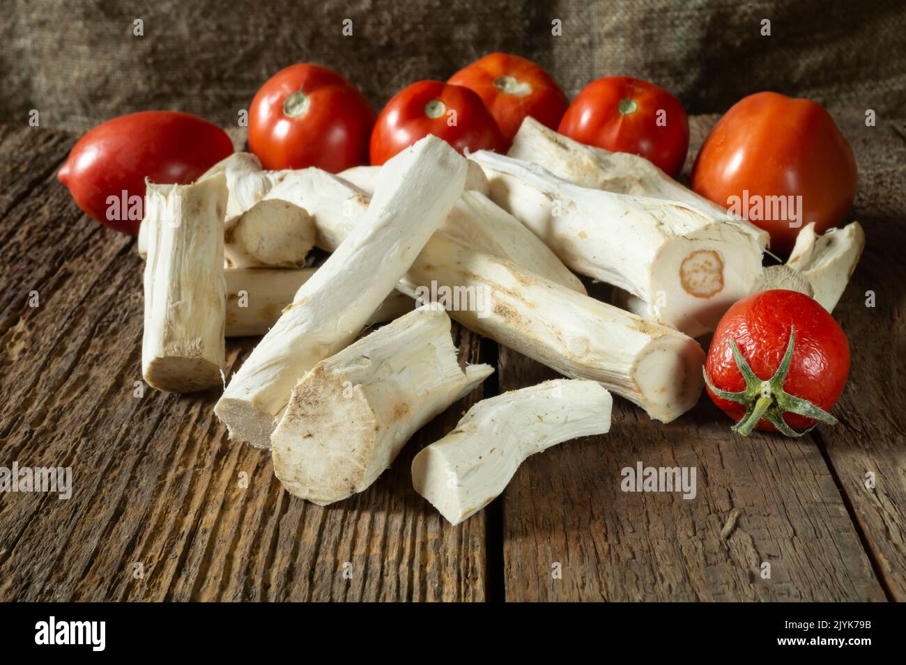 Rote Tomaten und Meerrettich für einen würzigen Snack. Essen auf dunklem Hintergrund Stockfoto