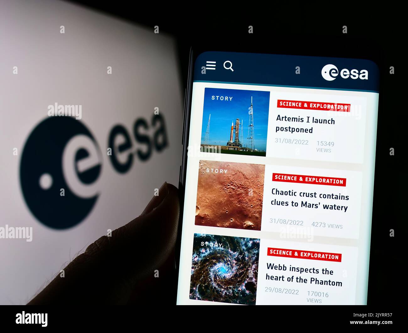 Person mit Mobiltelefon und Webseite der europäischen Organisation European Space Agency (ESA) auf dem Bildschirm mit Logo. Konzentrieren Sie sich auf die Mitte des Telefondisplays. Stockfoto