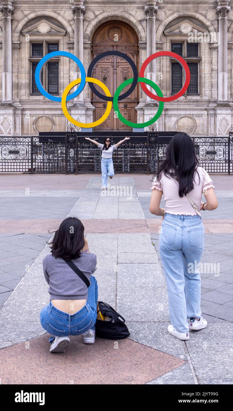 Asiatische Touristen fotografieren vor dem Schild der Olpymic Games am Hôtel de Ville, dem Rathaus von Paris, Frankreich Stockfoto