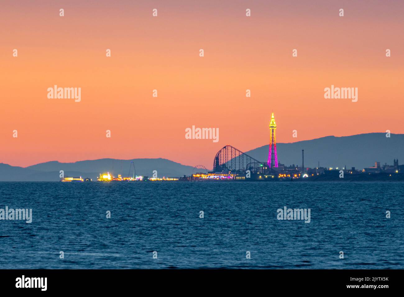 Blackpool Attraktionen vor einem Abendhimmel mit Hügeln von Cumbria im Hintergrund. Blackpool Tower, The Big One, Central Pier. Fylde Coast. England, Großbritannien Stockfoto