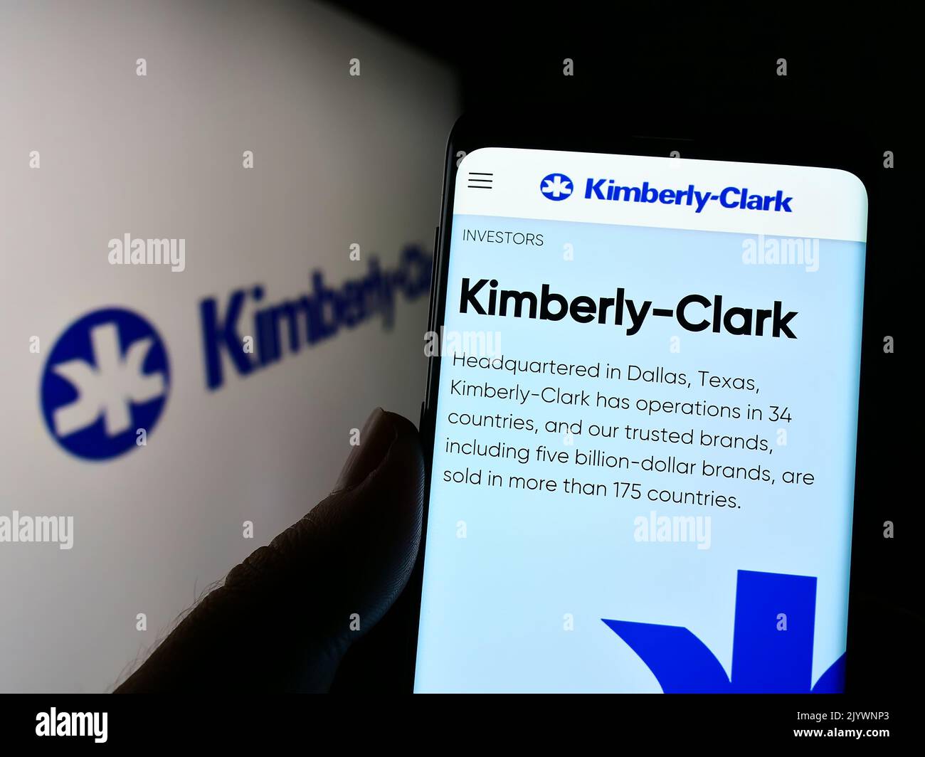 Person mit Smartphone und Webseite des Körperpflegeunternehmens Kimberly-Clark Corporation auf dem Bildschirm mit Logo. Konzentrieren Sie sich auf die Mitte des Telefondisplays. Stockfoto