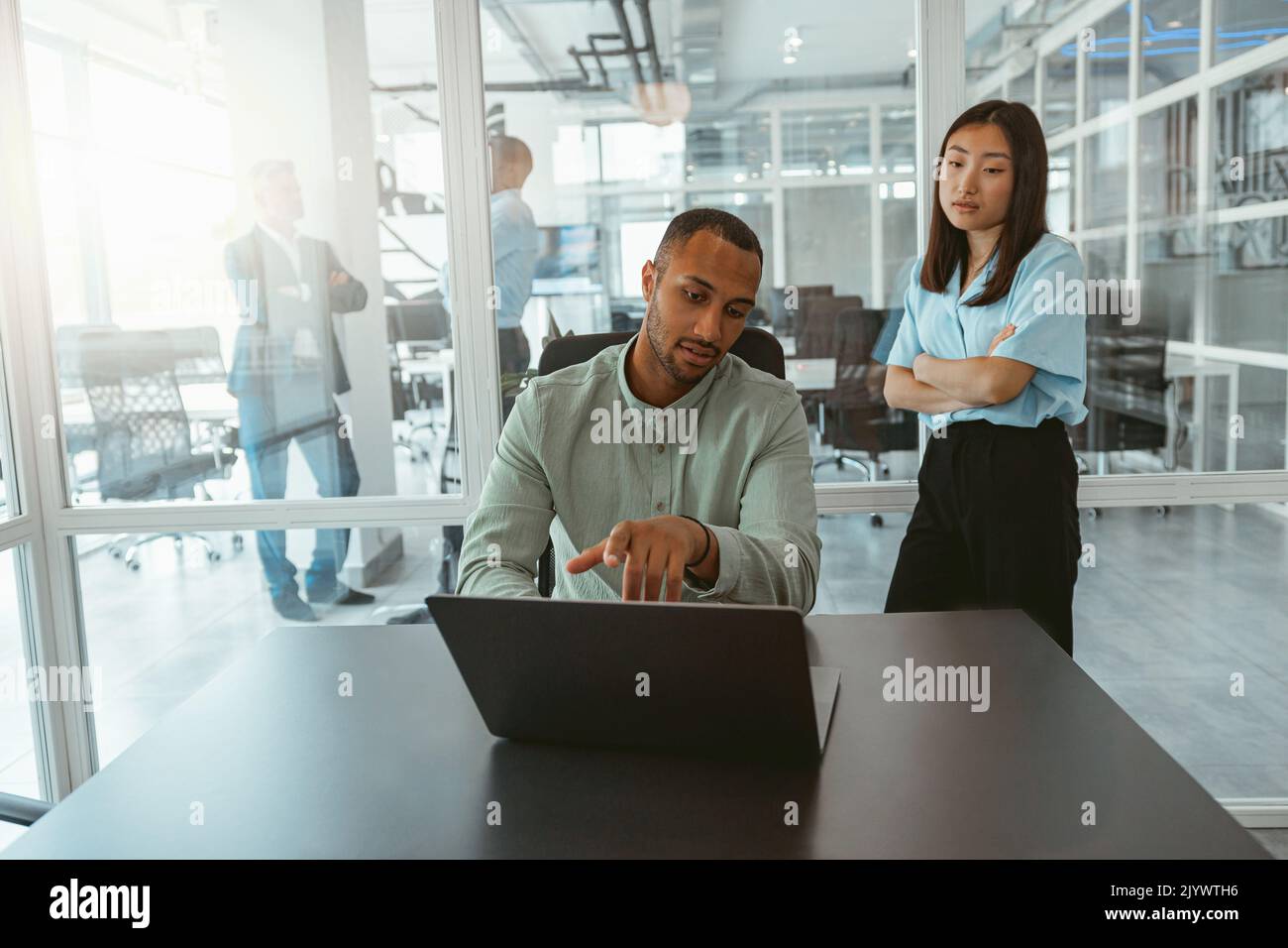 Zwei multiethnische Kollegen aus der Wirtschaft arbeiten in einem modernen Büro zusammen Stockfoto