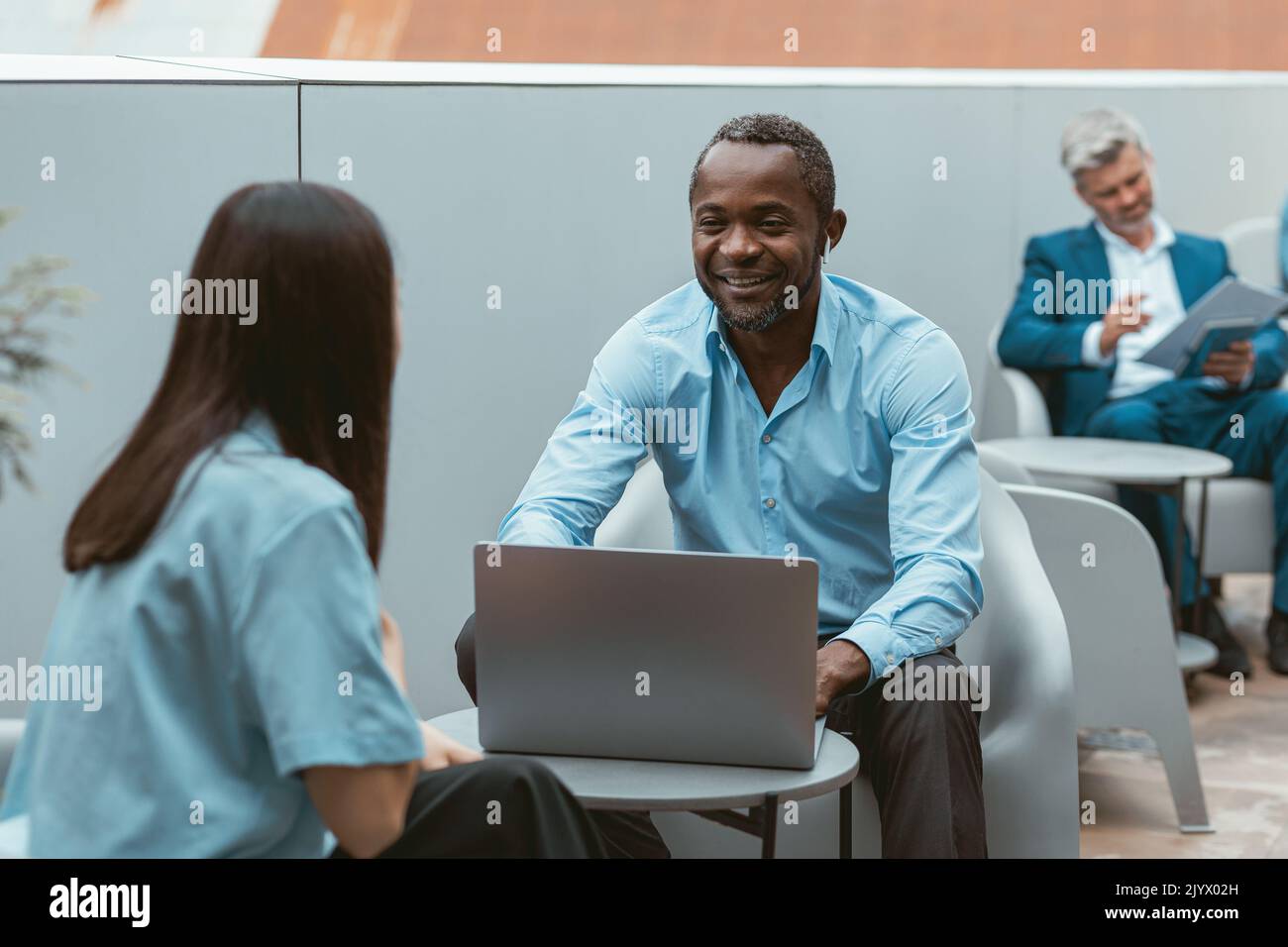 Zwei multiethnische Business-Kollegen arbeiten in modernem Coworking zusammen Stockfoto