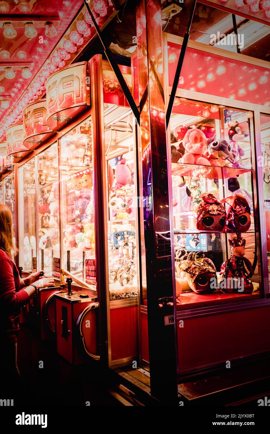 Person, die die Greifmaschine spielt, in der Hoffnung, auf der jährlichen Straßenmesse in St. Giles, Oxford, einen Preis für ein Kuscheltier zu gewinnen. Stockfoto