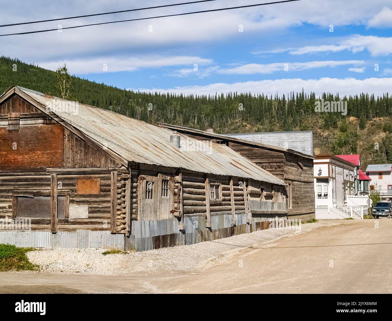 Blockhaus-Gebäude in einer staubigen Stadtstraße im historischen Bergbaugebiet Yukon Territory, Dawson City. Stockfoto