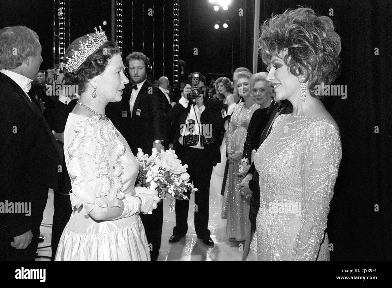 Datei-Foto vom 25/11/1985 von Queen Elizabeth II Treffen mit der Königin der Seifenopern, Dynasty Star Joan Collins, backstage nach der Royal Variety Performance im Theatre Royal, Drury Lane, London, in dem Joan half, einen Teil der Show zu präsentieren. Ausgabedatum: Donnerstag, 8. September 2022. Der Monarch war nicht von Prominenten angewidert und traf im Laufe der Jahrzehnte auf Hunderte von Showbiz-Stars, Pop-Legenden und Hollywood-Größen, aber viele gaben zu, Nerven zu haben, als sie dem berühmten, lang regierenden Herrscher gegenüberstanden. Stockfoto