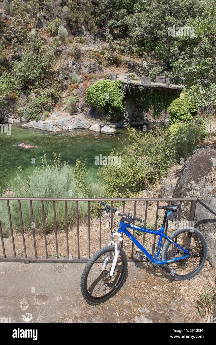 MTB-Fahrrad neben dem natürlichen Schwimmbad La Maquina, Guijo de Santa Barbara, Spanien. Toller Ort für Triathlon-Praktizierende Stockfoto