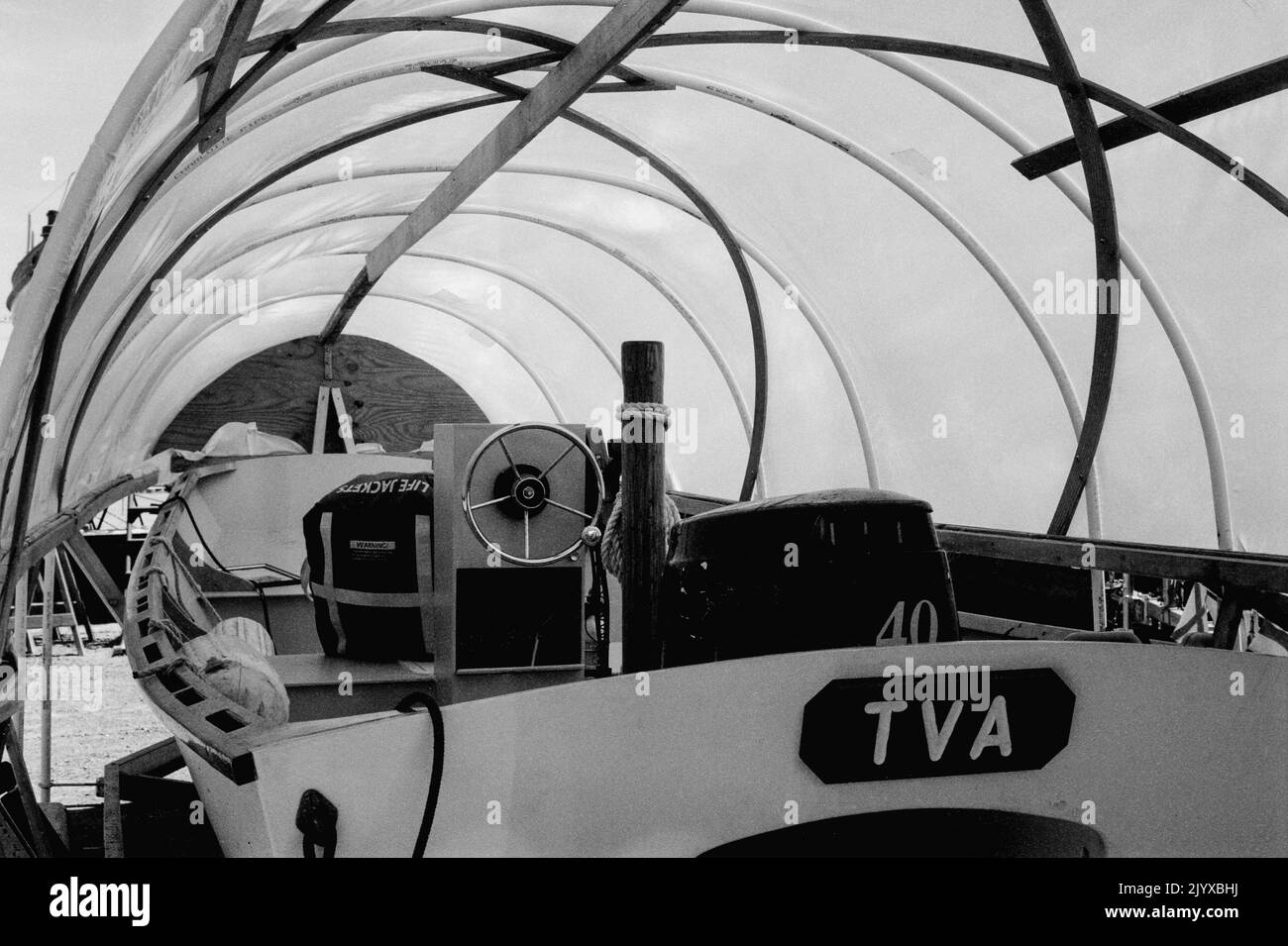 Ein kleines hölzerner Motorboot ist unter einem Tuch Canpoe im Essex Shipbuilding Museum - Essex, Massachusetts geschützt. Bild, das auf einem analogen Film aufgenommen wurde. Stockfoto