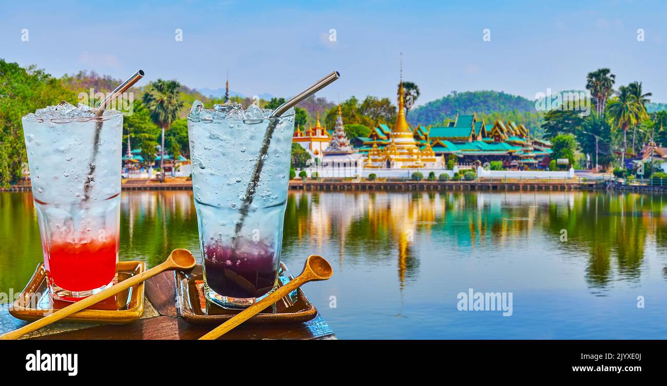 Genießen Sie die Cocktails auf den Felsen im Seeufer-Restaurant am Nong Kham Lake mit dem Tempel Wat Chong Klang im burmesischen Stil im Hintergrund, Mae Hong Son, Thail Stockfoto