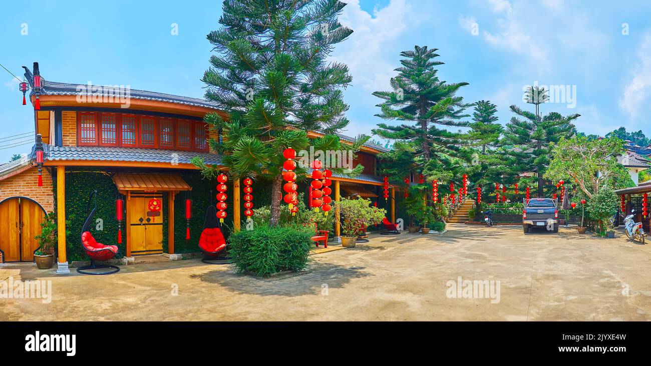 Die kleinen Häuser, leuchtend roten chinesischen Laternen und hohen üppigen Norfolk Island Pines im Resort von Ban Rak Thai Yunnan Teeldorf, Thailand Stockfoto