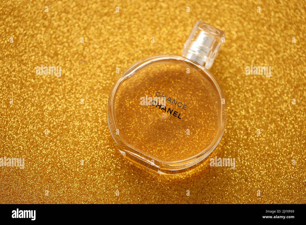 TERNOPIL, UKRAINE - 2. SEPTEMBER 2022 Chanel Chance weltberühmte französische Parfümflasche auf glänzendem Glitzer-Hintergrund in goldenen und gelben Farben Stockfoto