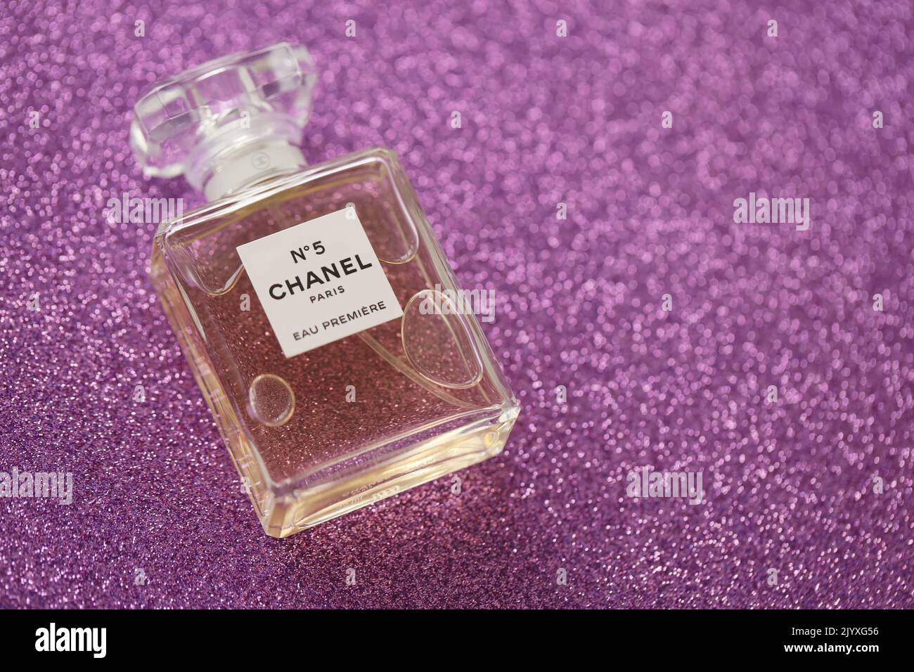 TERNOPIL, UKRAINE - 2. SEPTEMBER 2022 Chanel Number 5 Eau Premiere weltweit berühmte französische Parfümflasche auf glänzendem Glitzer-Hintergrund in Pink und Purpé Stockfoto