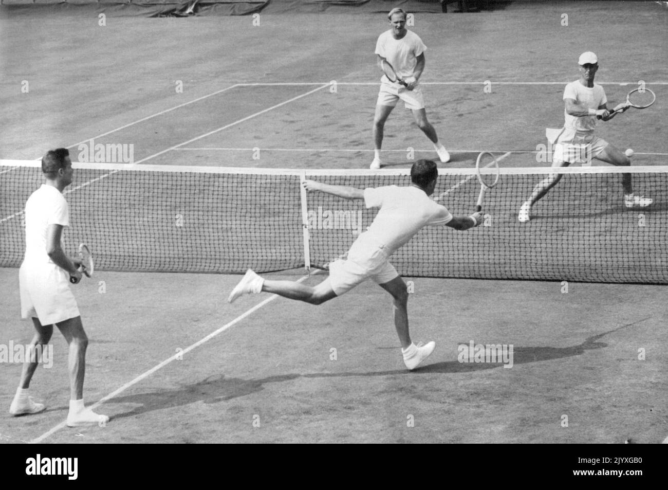 Billy Talbert (rechts, Vorplatz) von der US-Mannschaft trifft den Ball gegen den australischen Bill Sidwell (mit Mütze) im zweiten Satz des Davis Cup Doubles-Spiels im West Side Tennis Club in Forest Hills, New York, am 27. August. Links ist Gardnar Mulloy, Talberts Partner. John Bromwich, Sidwell's Partner, beobachtet die Aktion am fernen Gericht. Das US-Team führte in der Pause zwei Sätze zu einem. 12. September 1949. Stockfoto