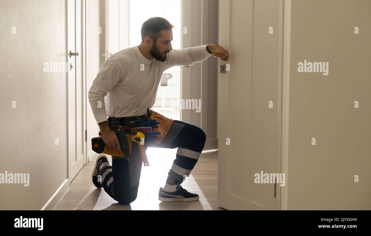 Portrait Junge männliche Tischler reparieren Türschloss Stockfoto