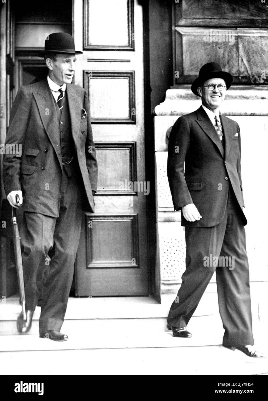 Lord Halifax und der amerikanische Botschafter lächeln, als sie nach der Kabinettssitzung verlassen: Lord Halifax (links) und Mr. Joseph Kennedy lächeln, als sie Nr. 10 verlassen. Lord Halifax, der Außenminister, und Joseph Kennedy, der amerikanische Botschafter, lächelten mit einem breiten Lächeln, als sie nach der Kabinettssitzung die Nummer 10, Downing Street, London, verließen, um die britische Antwort auf Hitler zu prüfen. 27. August 1939. Stockfoto