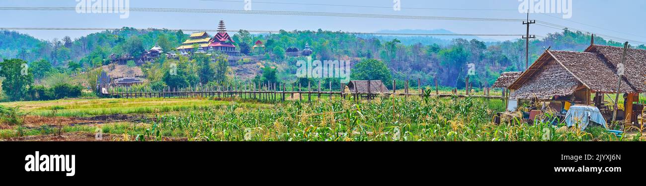 Panorama der grünen Felder mit alten Su Tong Pae Bambusbrücke, umgeben von Hügeln und mit Wat Tham Poo Sa Ma Tempel im Hintergrund, Mae Hong Stockfoto