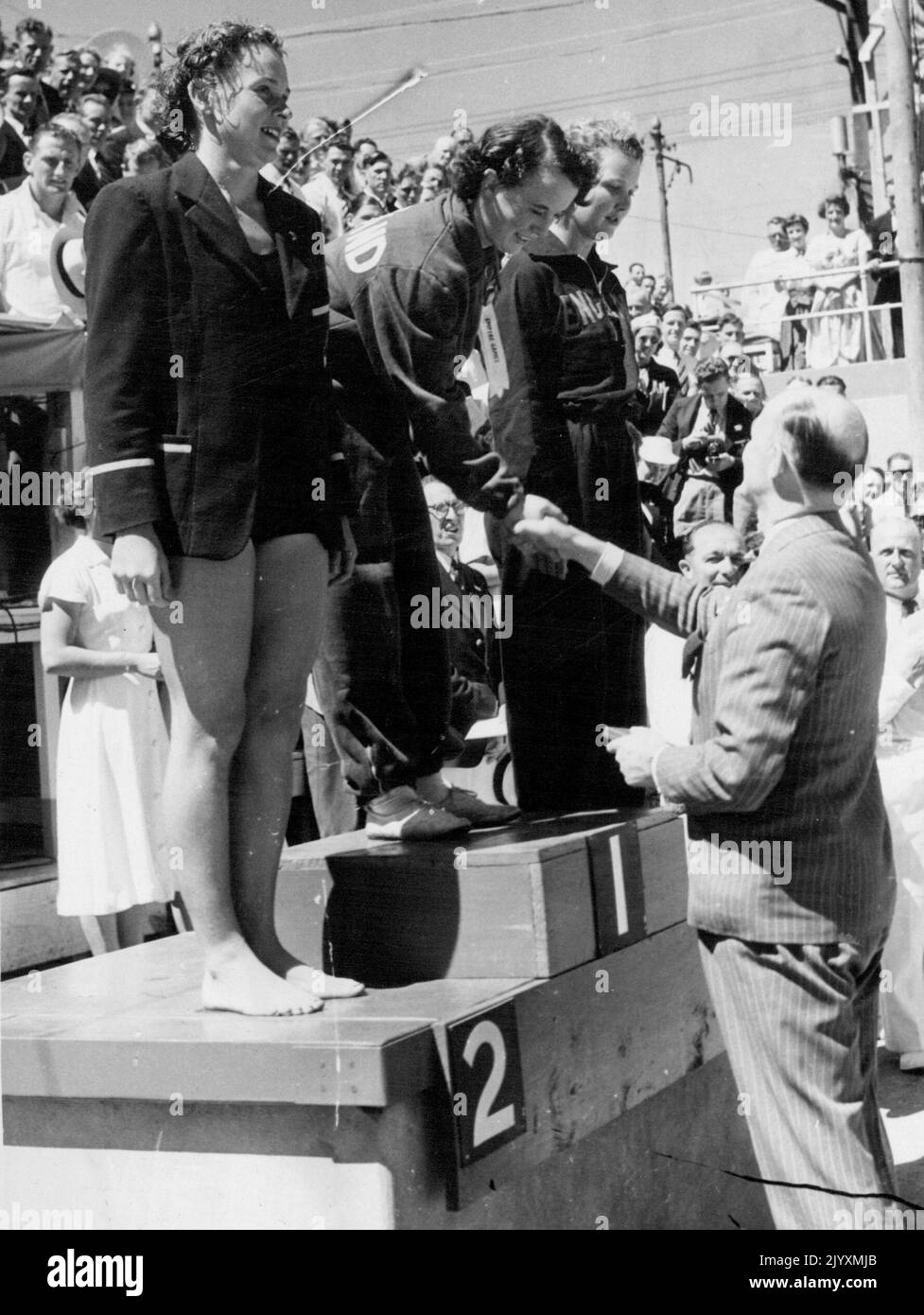 H. O. Gordon (Schottland), Gewinner des Frauenpanzerfinales von 220yds, B. N. Lyons (Australien), Second und E. Church (England), Dritter, wurde von A. E. Porritt, Vorsitzender des britischen Empire Games Federation, gratuliert. 16. Februar 1950. Stockfoto