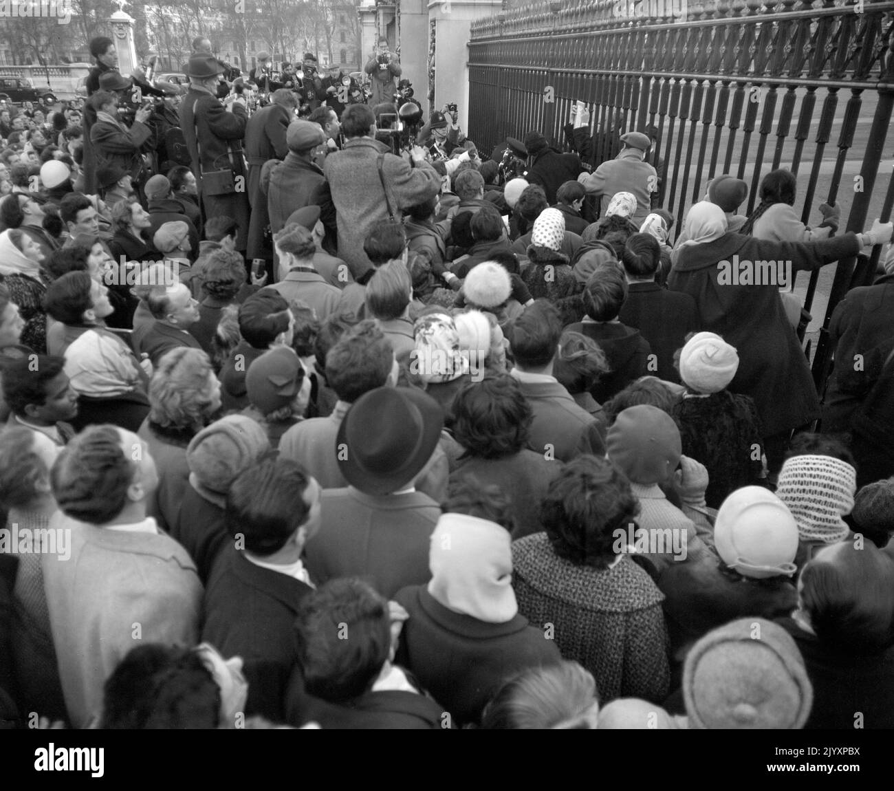 Aktenfoto vom 19/2/1960 von einer Menge von 2.000 Personen, die als Bulletin die Geburt eines Sohnes - später als Prinz Andrew genannt - an Königin Elizabeth II. Ankündigen, wird von Stanley Williams, Superintendent des Palastes, am Geländer des Buckingham Palace befestigt. Königliche Todesfälle werden in der Regel durch die uralte Tradition bestätigt, im Buckingham Palace und in anderen königlichen Residenzen eine Bekanntmachung zu zeigen. Ausgabedatum: Donnerstag, 8. September 2022. Stockfoto